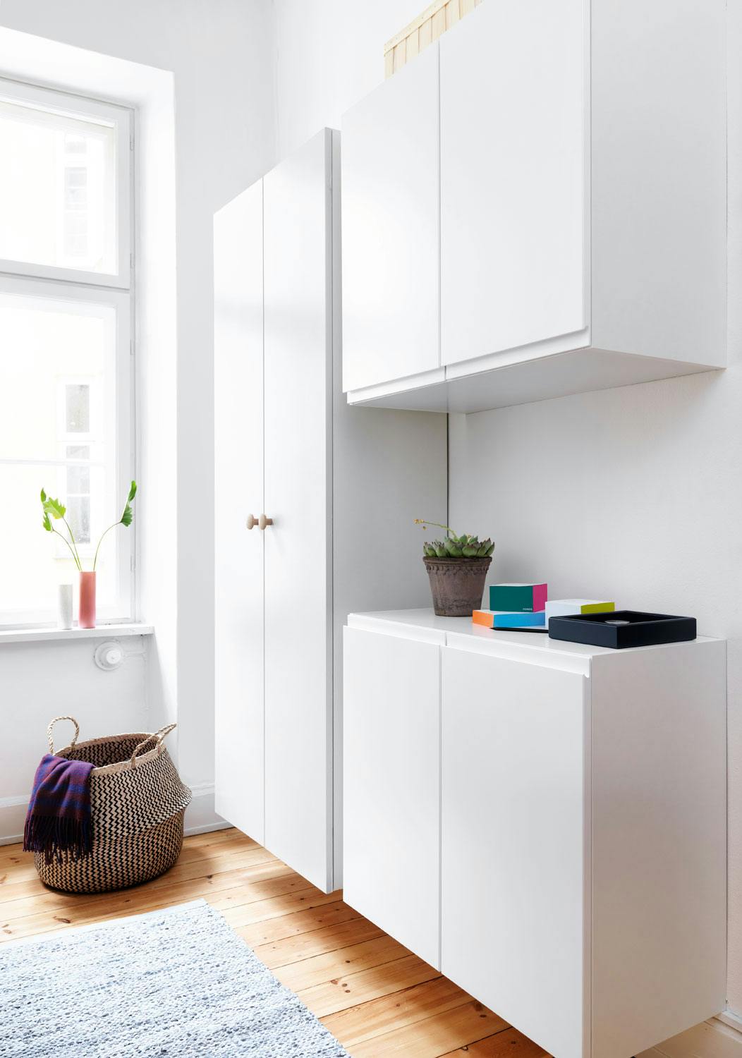 Luftig og ryddig med vegghengte skap Hvite plassbygde garderobeskap